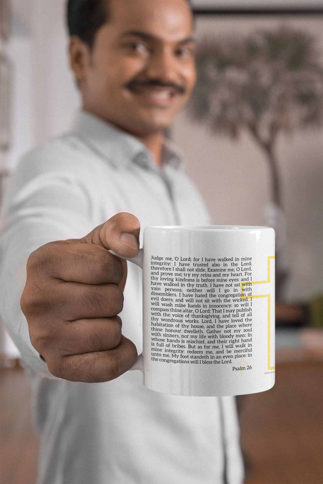 a man in a white shirt is holding a coffee mug