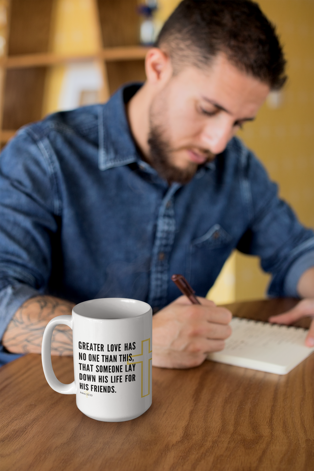 a man sitting at a table writing on a notepad