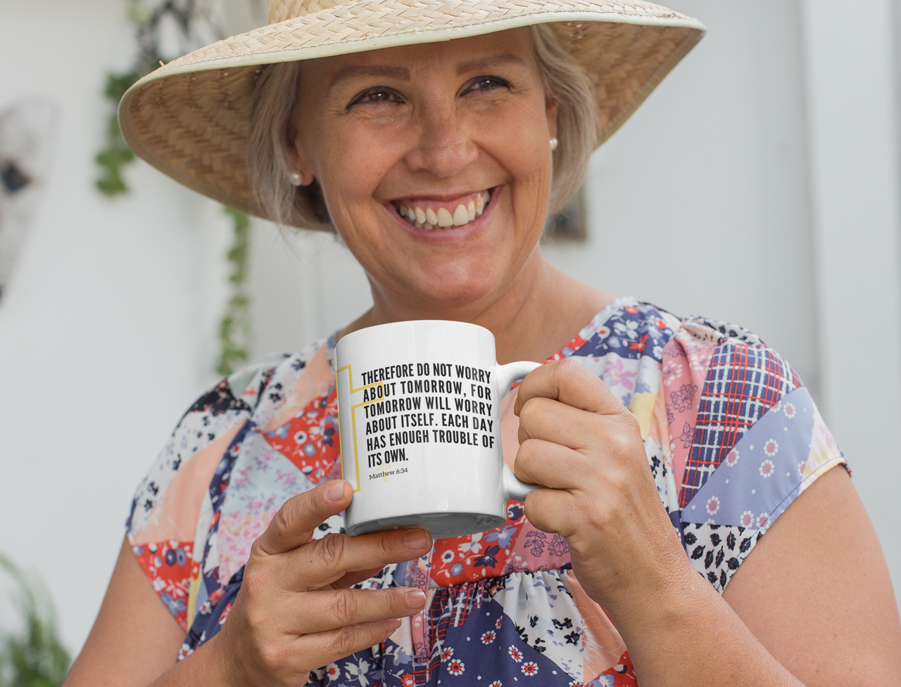 a woman wearing a straw hat holding a coffee mug