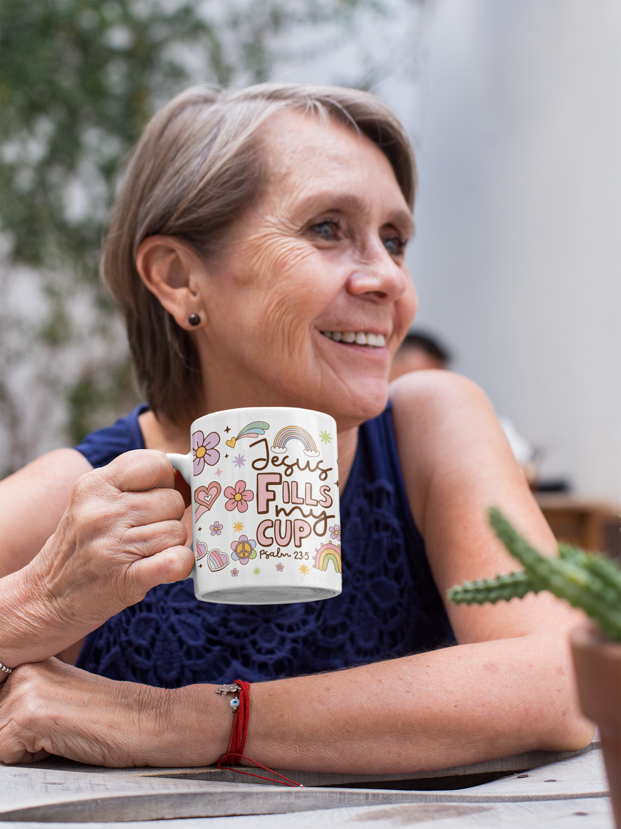 a woman sitting at a table holding a coffee mug