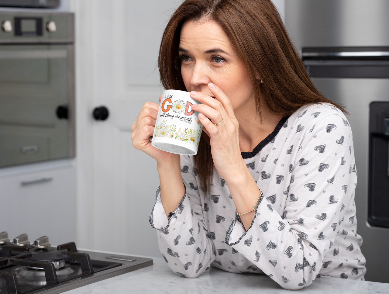 a woman drinking a cup of coffee in a kitchen