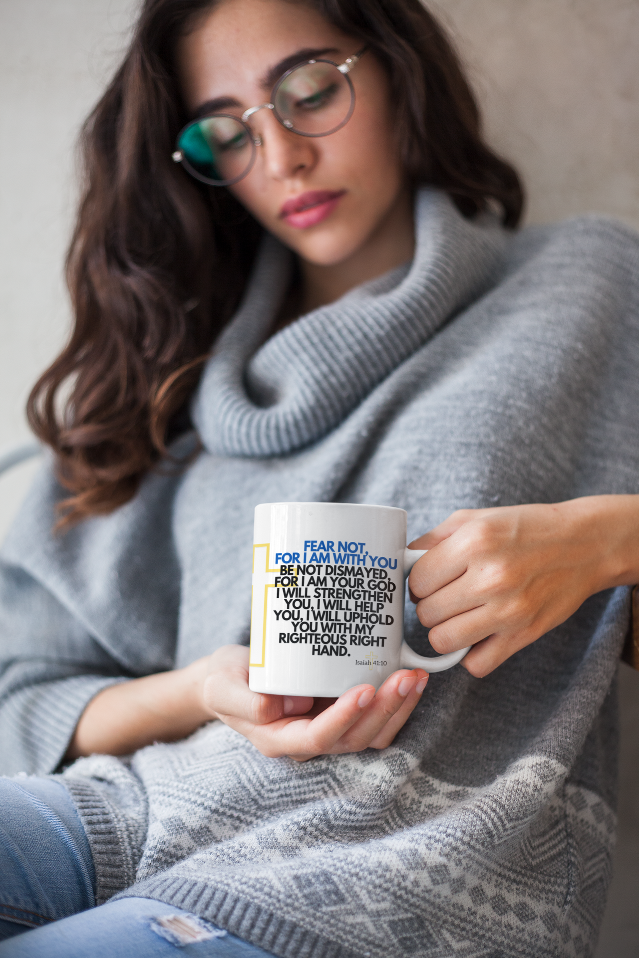 a woman wearing glasses holding a coffee mug