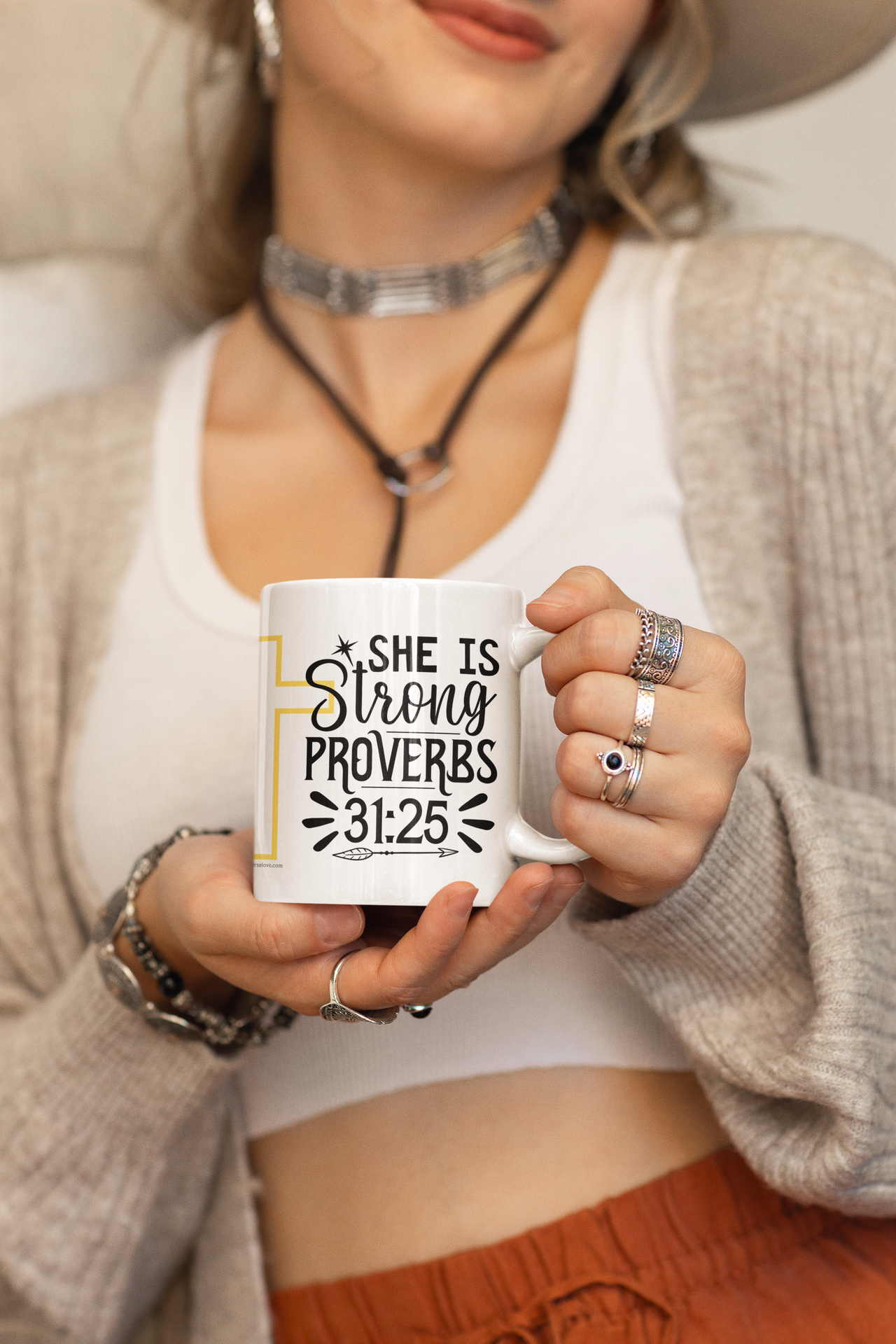 a woman wearing a hat holding a coffee mug