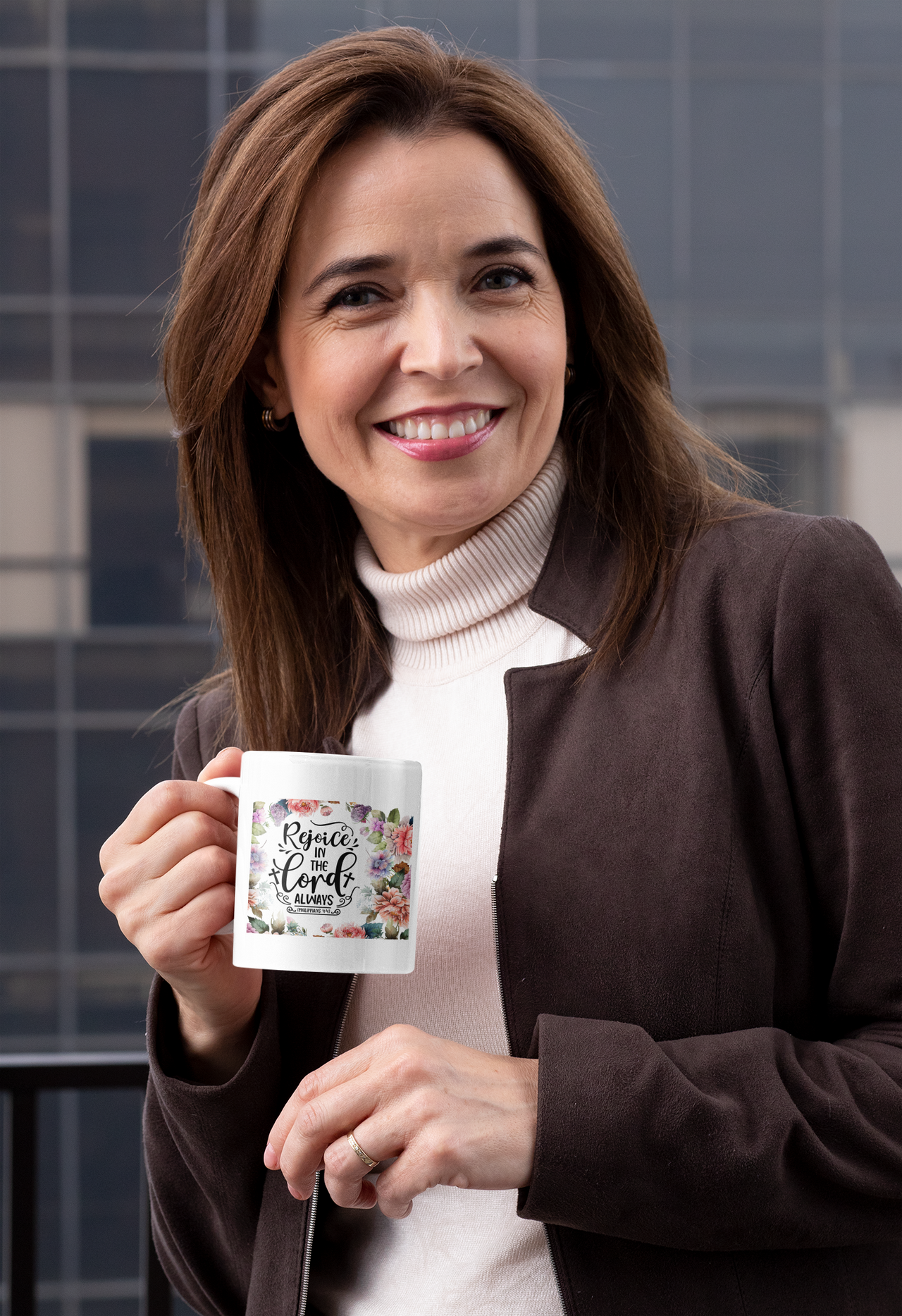 a woman is holding a coffee mug and smiling