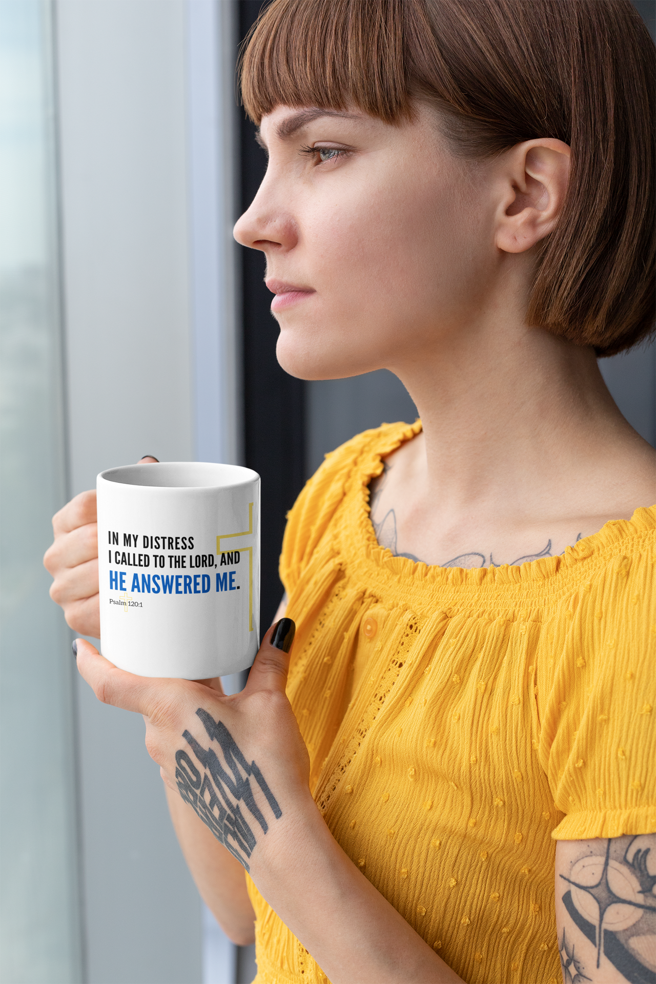 a woman with a tattooed arm holding a coffee mug