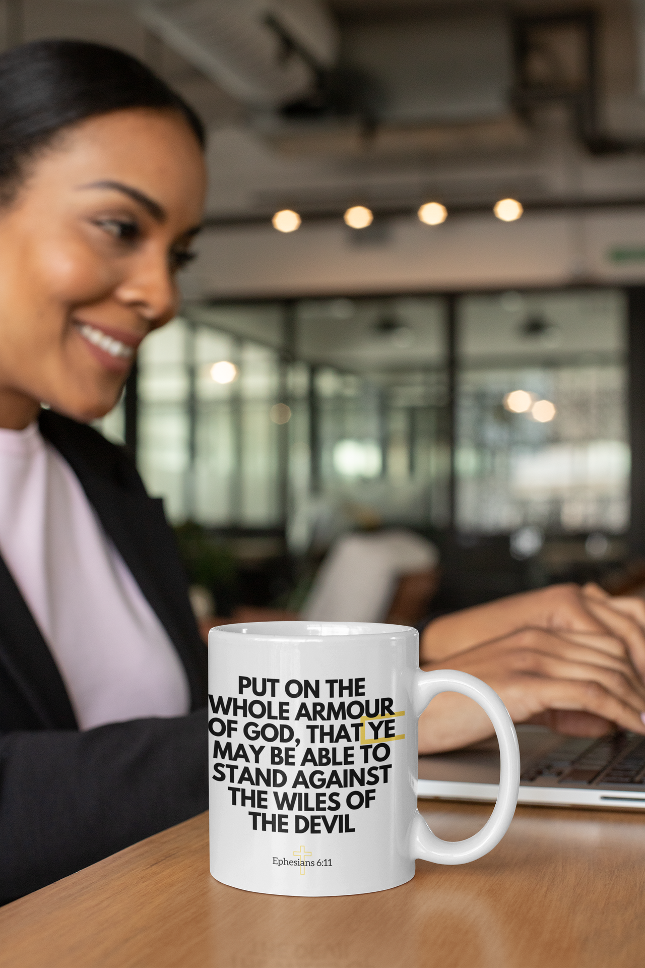 a woman sitting at a table with a coffee mug in front of her