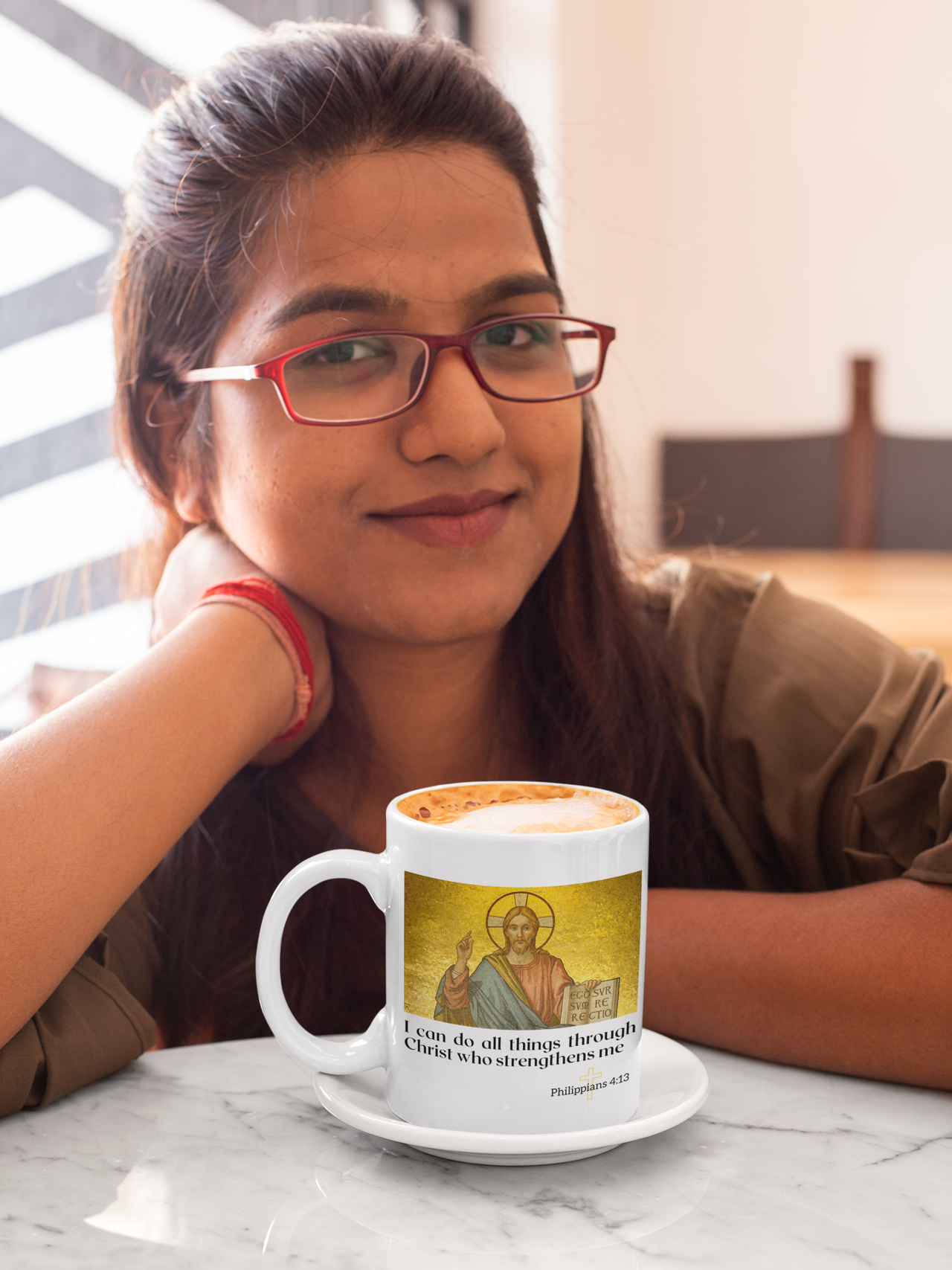 a woman sitting at a table with a coffee mug