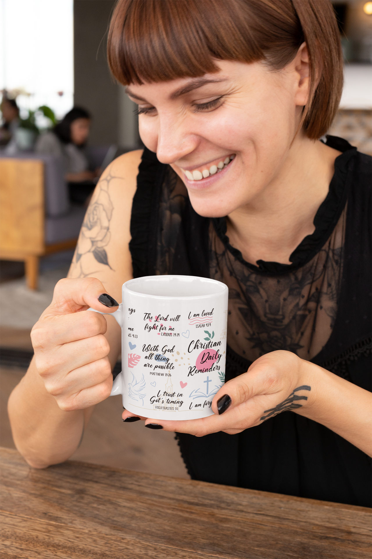 a woman sitting at a table holding a coffee mug