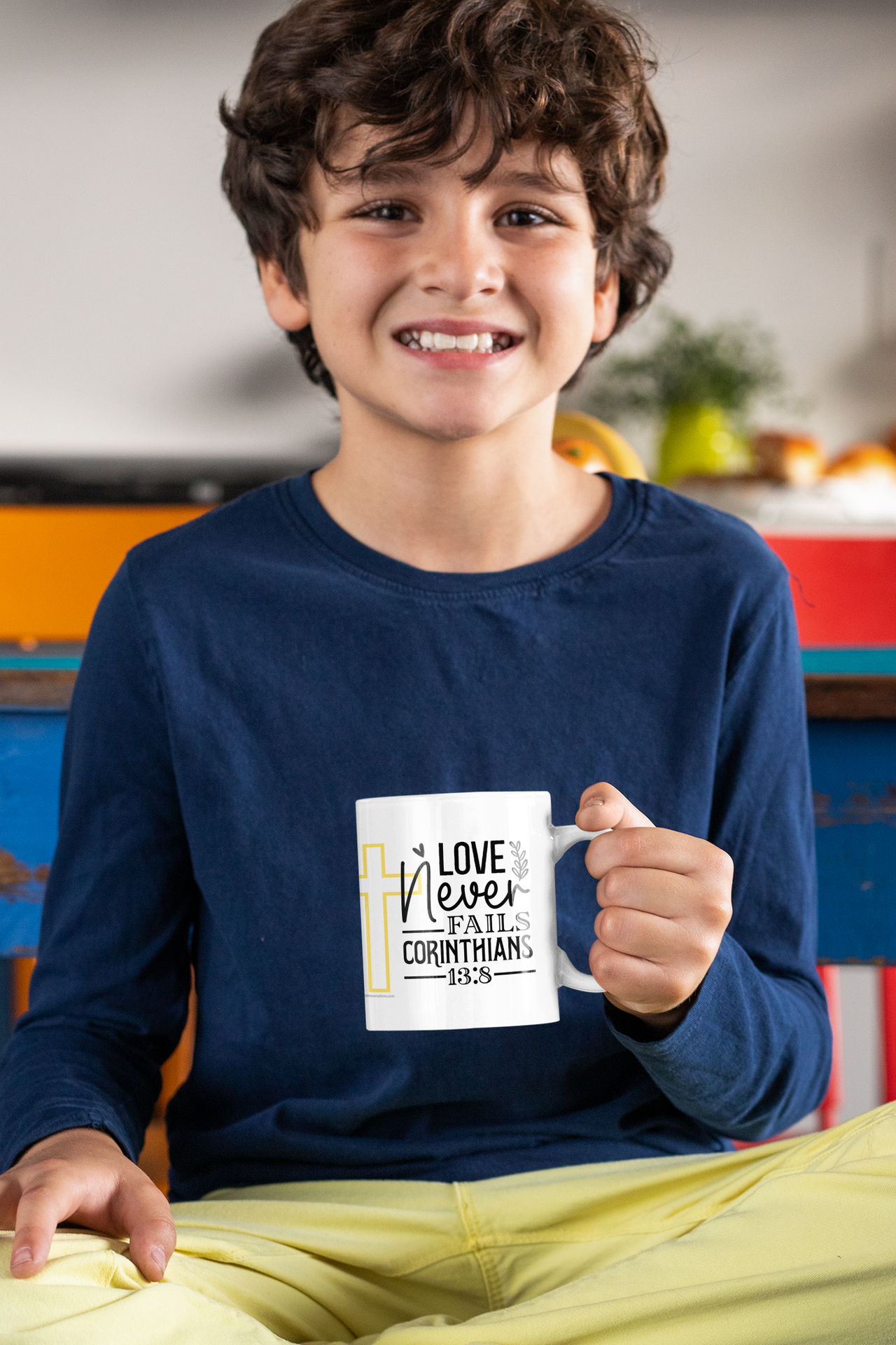 a young boy is holding a coffee mug