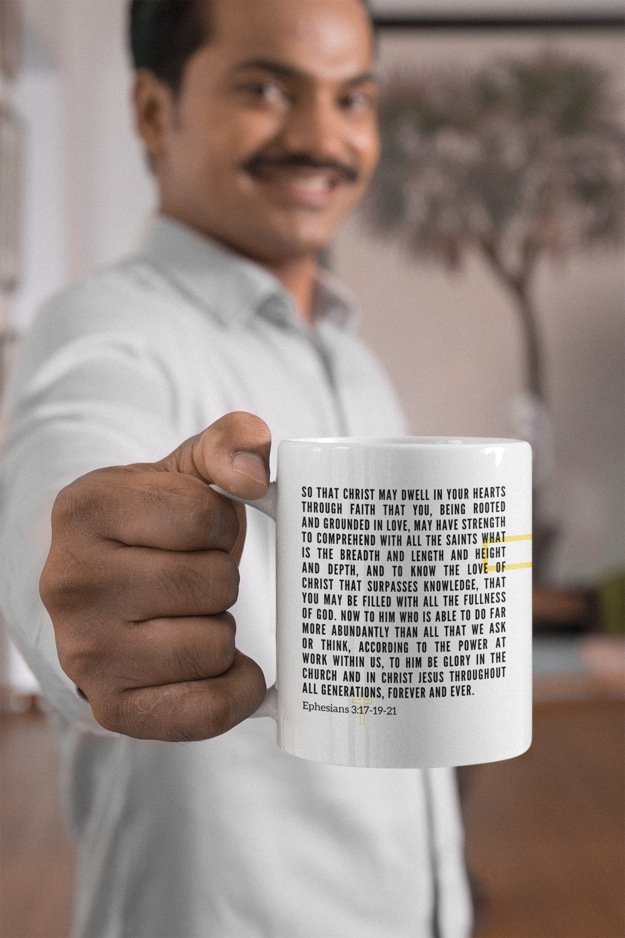 a man in a white shirt is holding a coffee mug