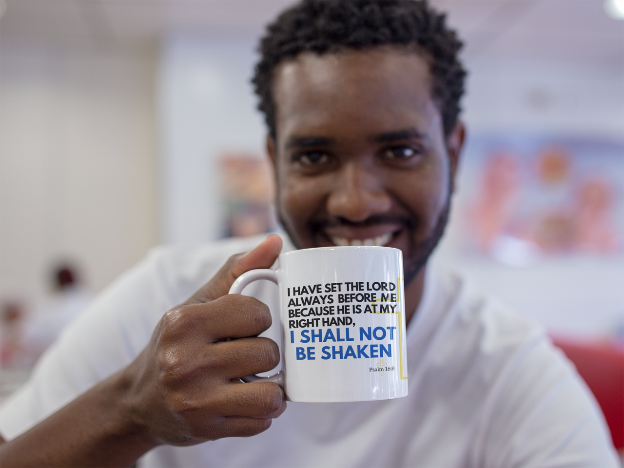 a man holding a coffee mug with a message on it