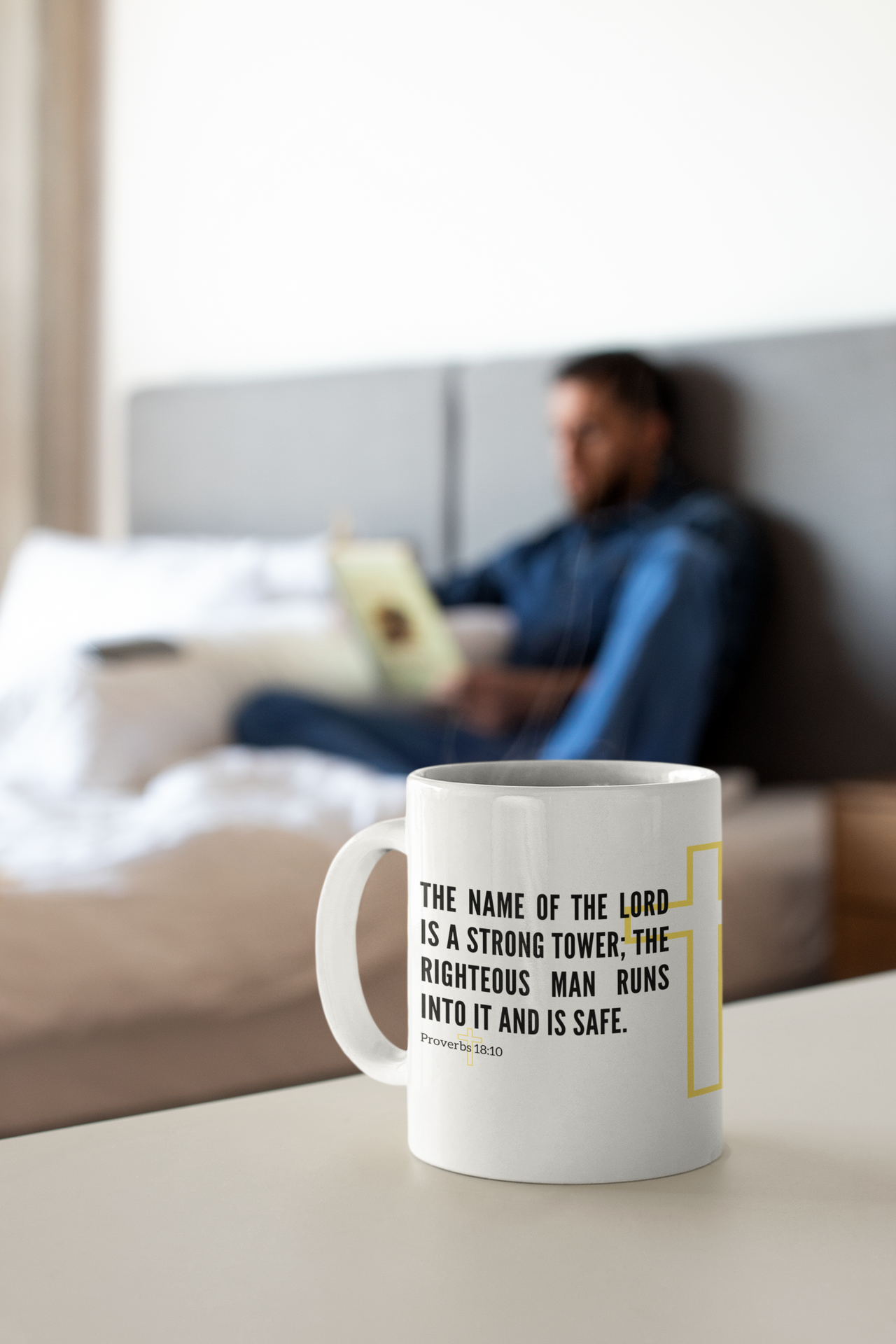 a coffee mug sitting on a table in front of a bed