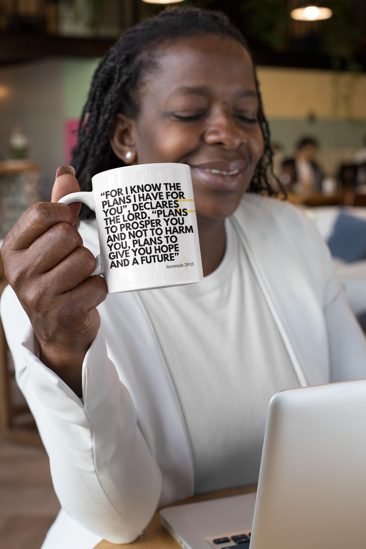 a woman sitting at a table holding a coffee mug