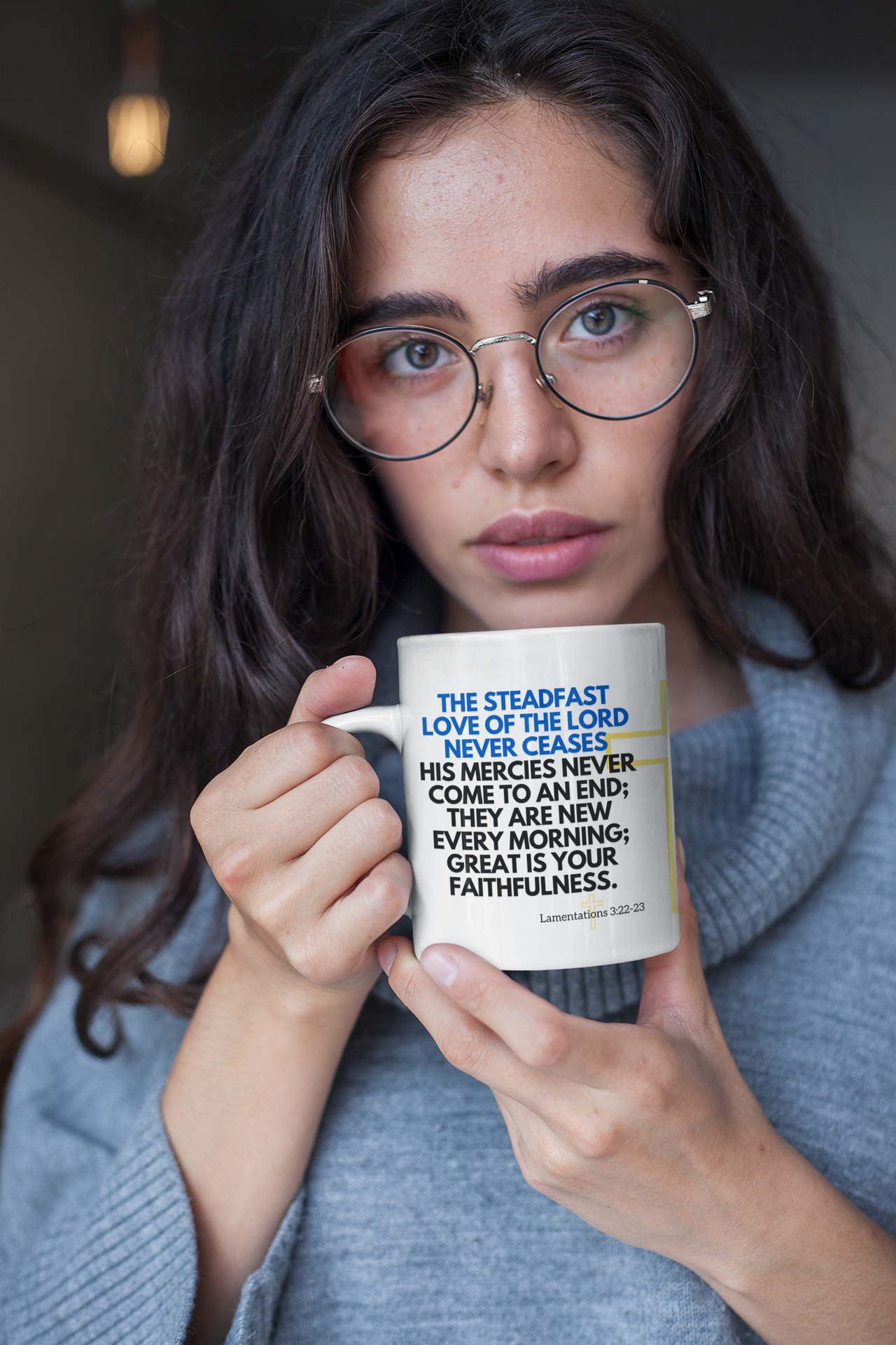 a woman wearing glasses holding a coffee mug