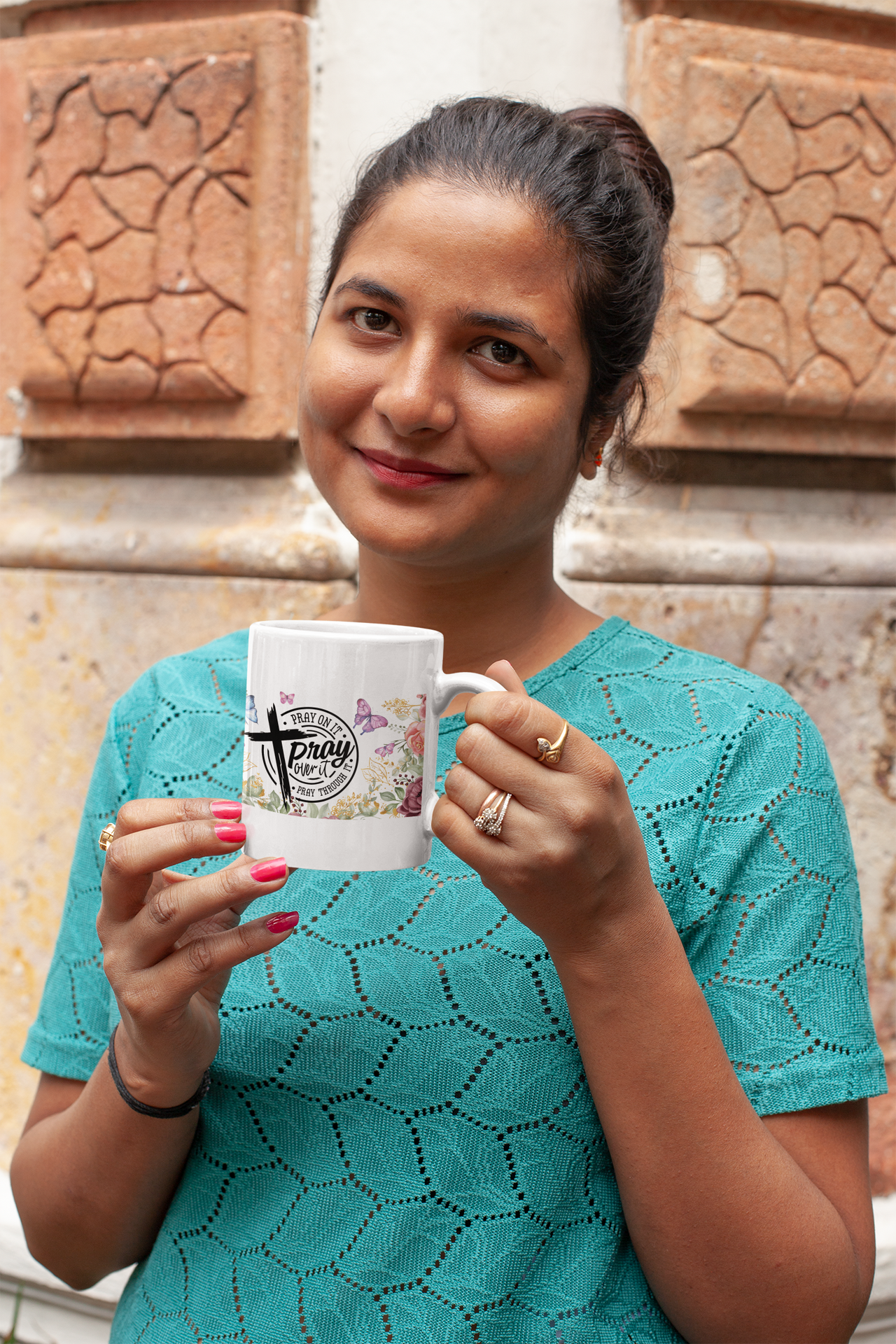 a woman holding a coffee mug in front of a building