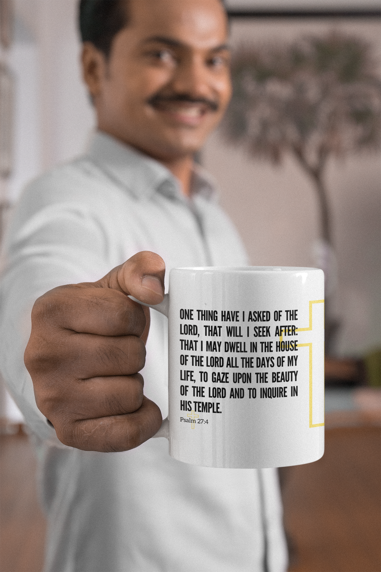 a man holding a coffee mug with a quote on it