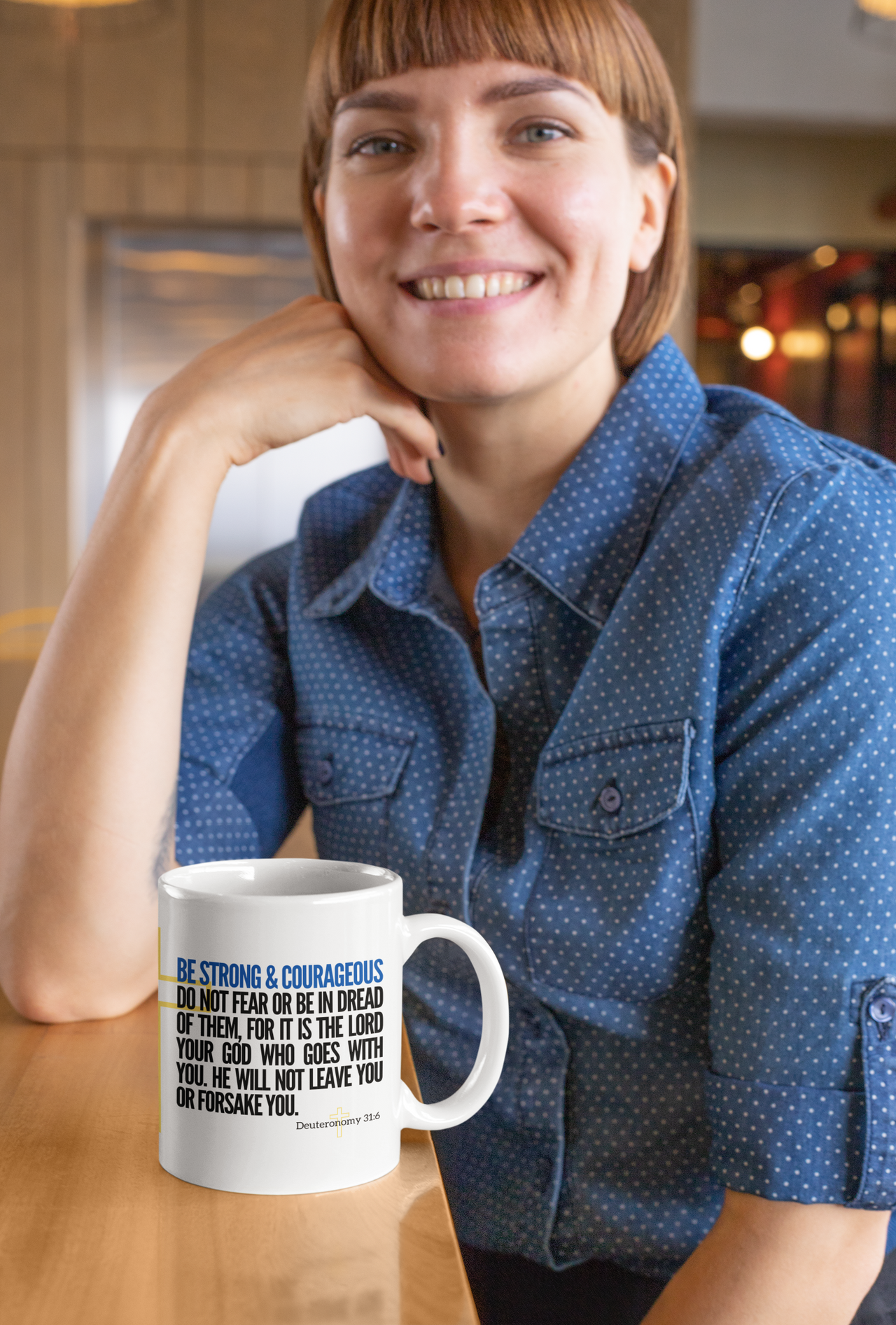 a woman sitting at a table with a coffee mug