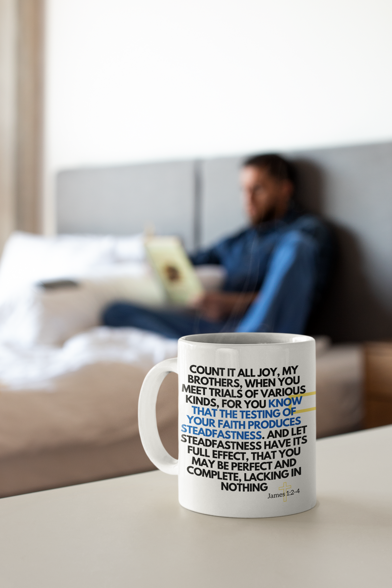 a coffee mug sitting on a table in front of a bed