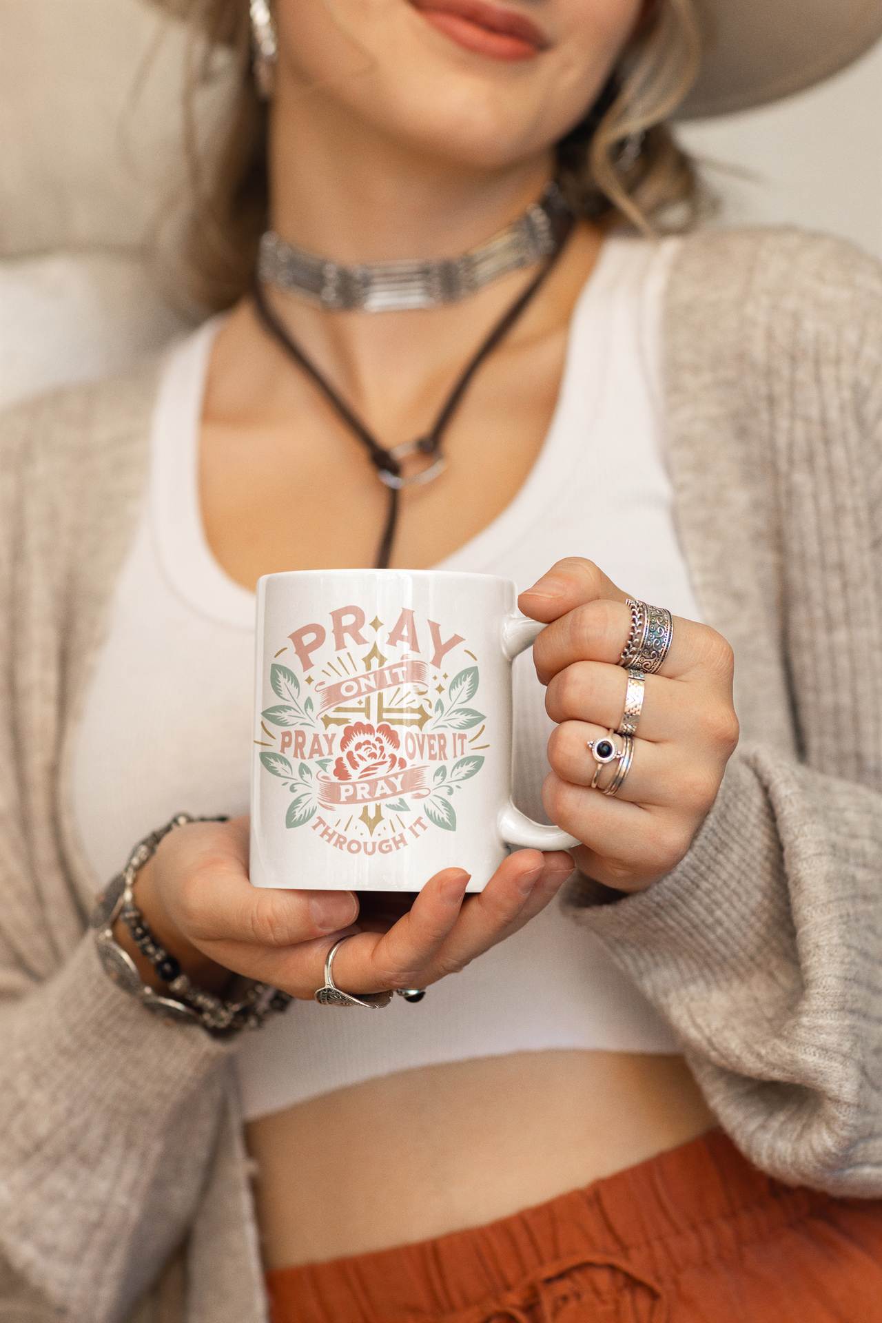 a woman wearing a hat holding a coffee mug