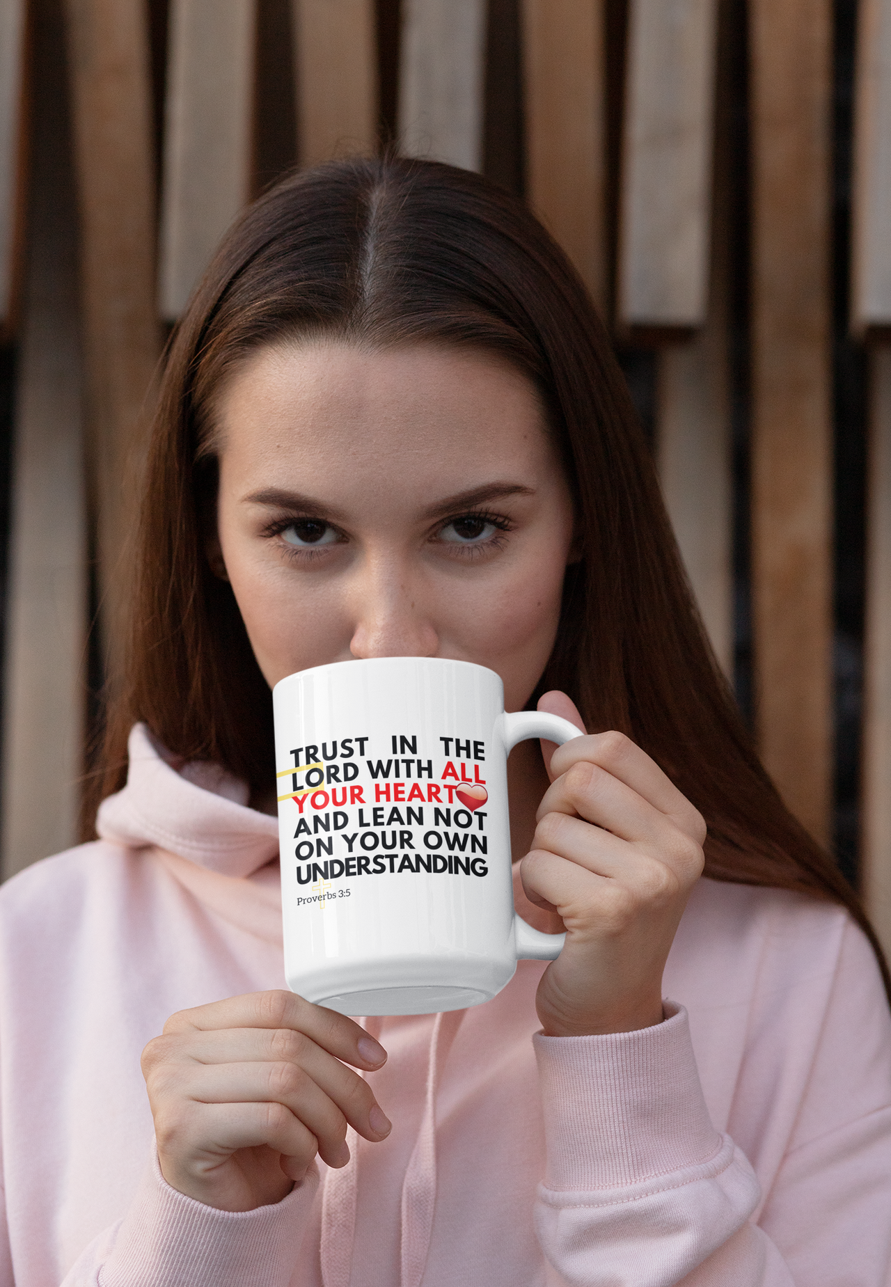 a woman in a pink hoodie holding a coffee mug